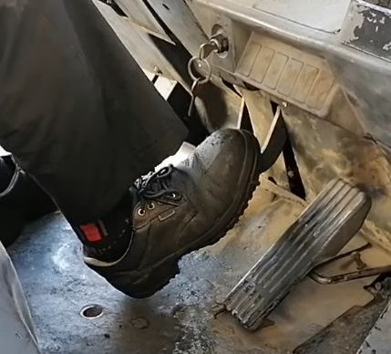 The foot of a Toyota forklift operator testing master cylinder performance and feeling brake pedal response