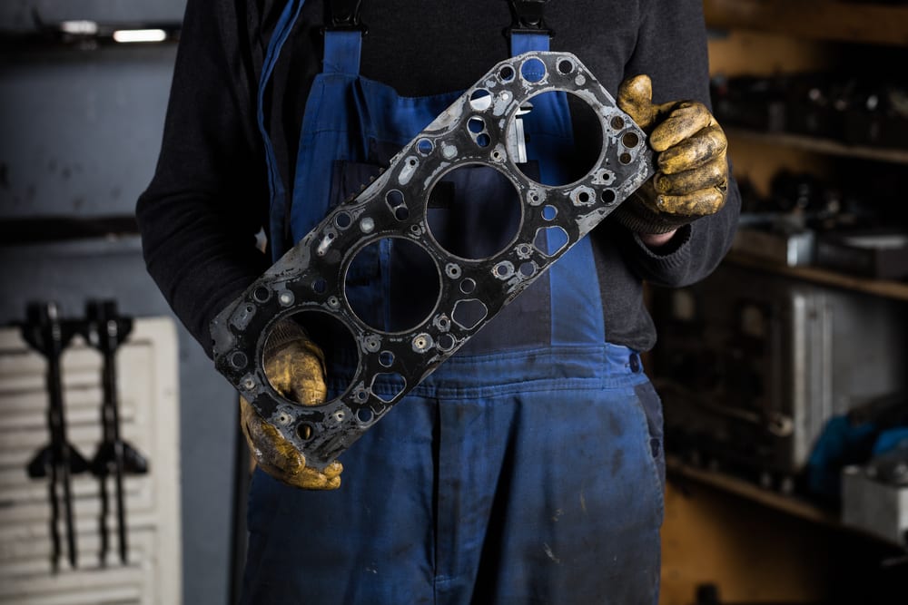 Mechanic holding an old and worn Clark forklift gasket
