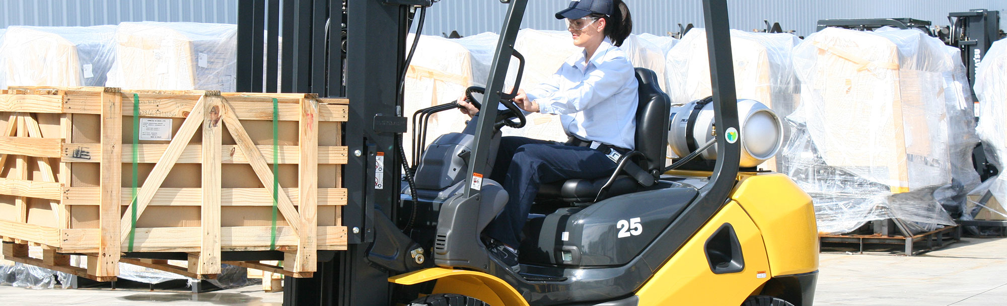  Woman driving a Komatsu forklift to moving a load outside of a warehousing 