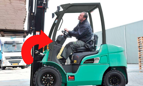 Lift truck operator using a Mitsubishi forklift to unload a load. The stabilizing action of the Mitsubishi forklift tilt cylinder it's highlighted by a red arrow.