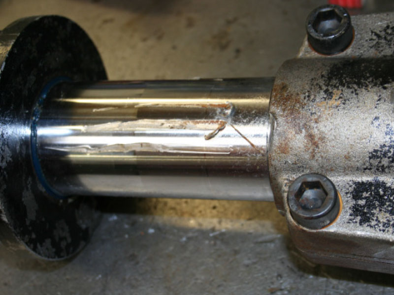 A Toyota forklift tilt cylinder with cracks on its piston.