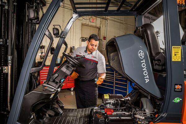 forklift mechanic preparing to change both the oil and the oil filter on a Toyota lift truck.